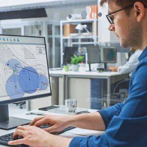 Man working on a blueprint at a desk.