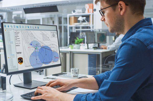 Man working on a blueprint at a desk.